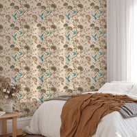 Botanical flower wallpaper behind a white bed with blue and beige linens.