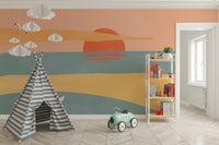 Coastal landscape wall mural with a large red sun over the horizon.