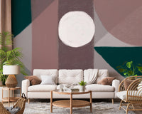 Neutral sofa placed against a dark green and dusty rose shape wall mural.