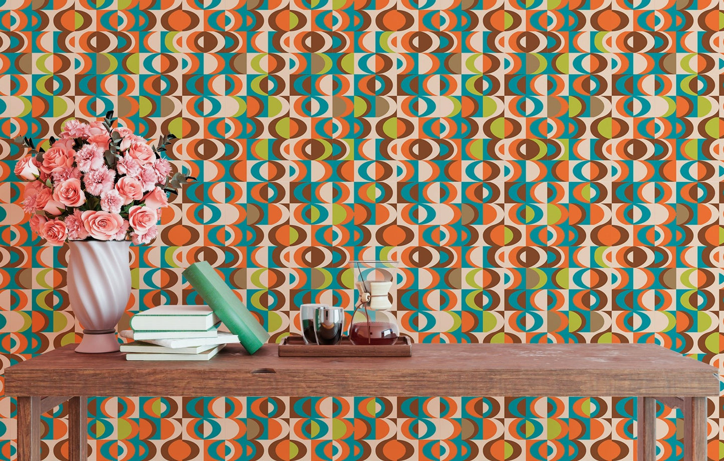 Retro geometric pattern wall mural behind a wooden table with pink flowers and books.