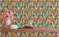 Retro geometric pattern wall mural behind a wooden table with pink flowers and books.