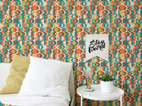 Abstract retro wall mural pattern behind a white bed with a yellow cushion.