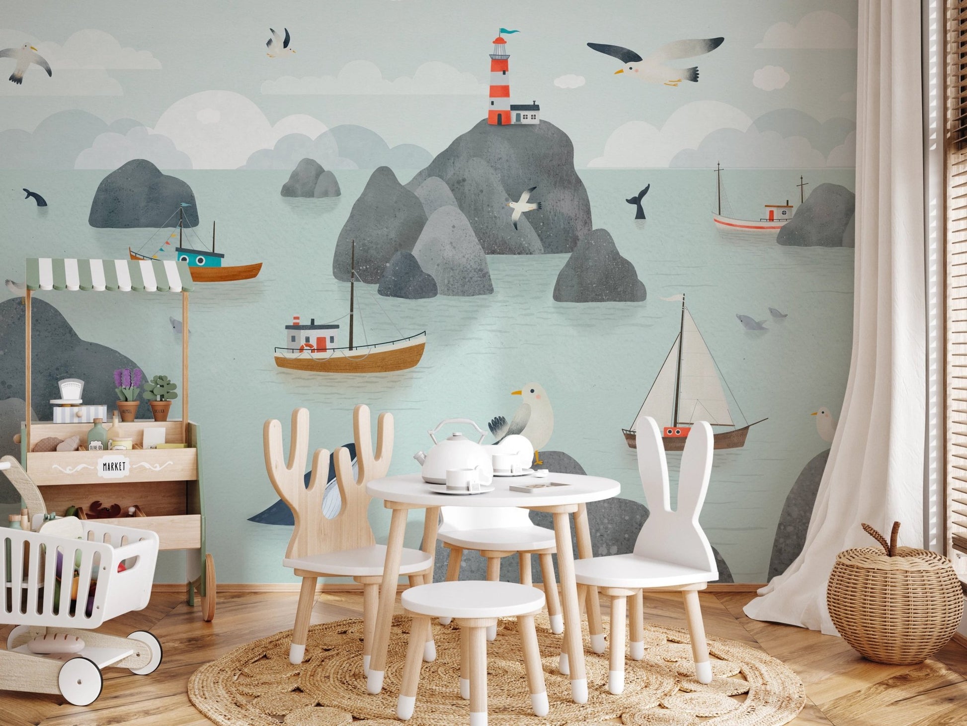 Play area featuring a lighthouse stories wall mural and white wooden table set.