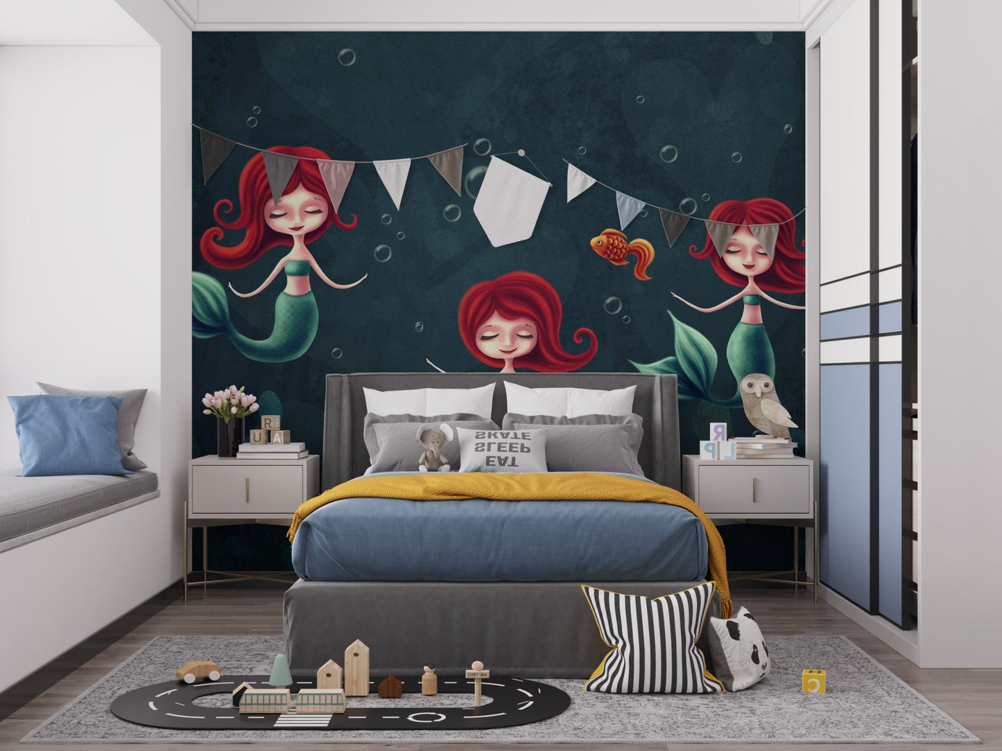 Three Underwater Mermaids Wall Mural in a kids bedroom with grey bed and bunting.