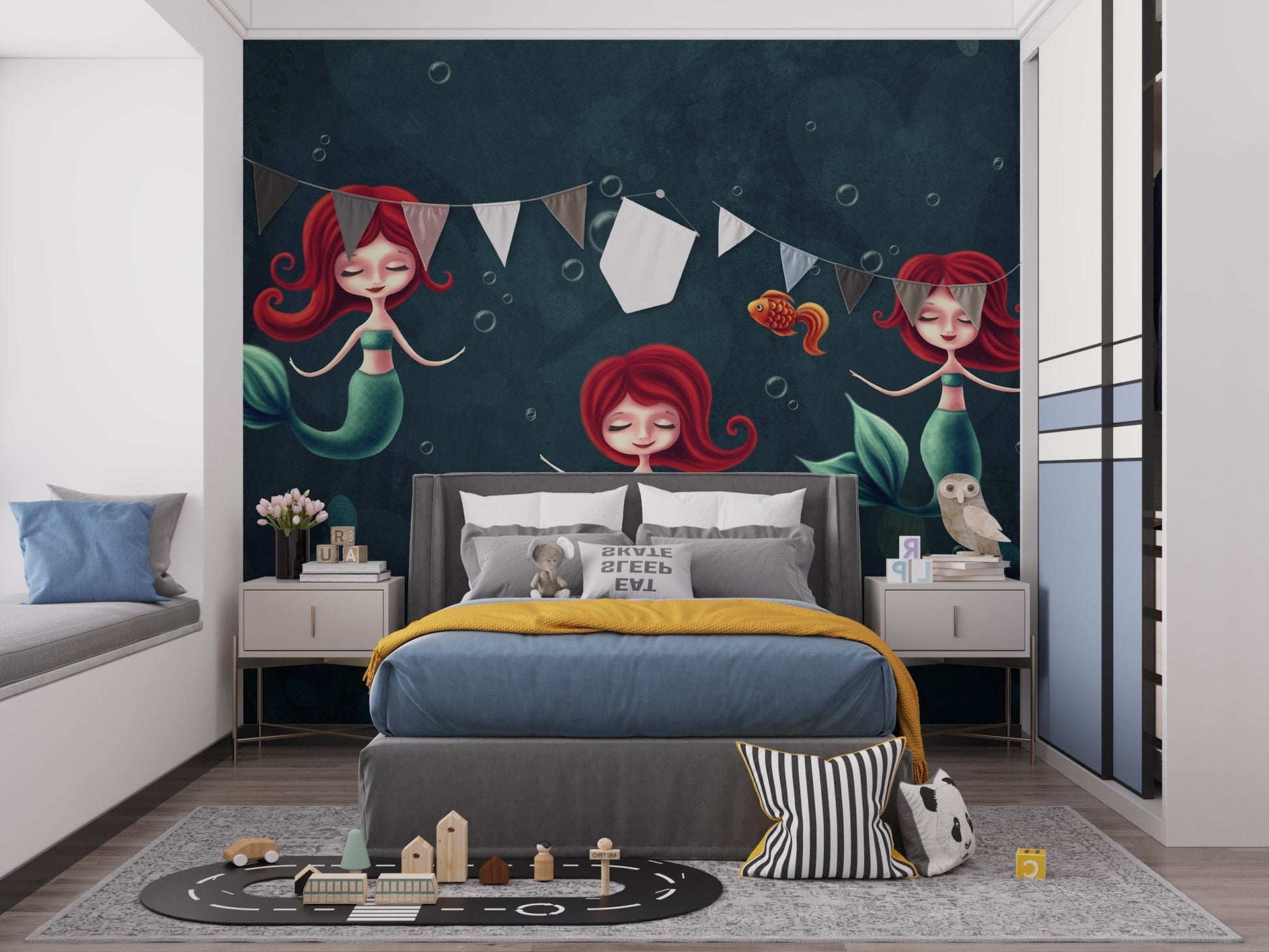 Three Underwater Mermaids Wall Mural in a kids bedroom with grey bed and bunting.