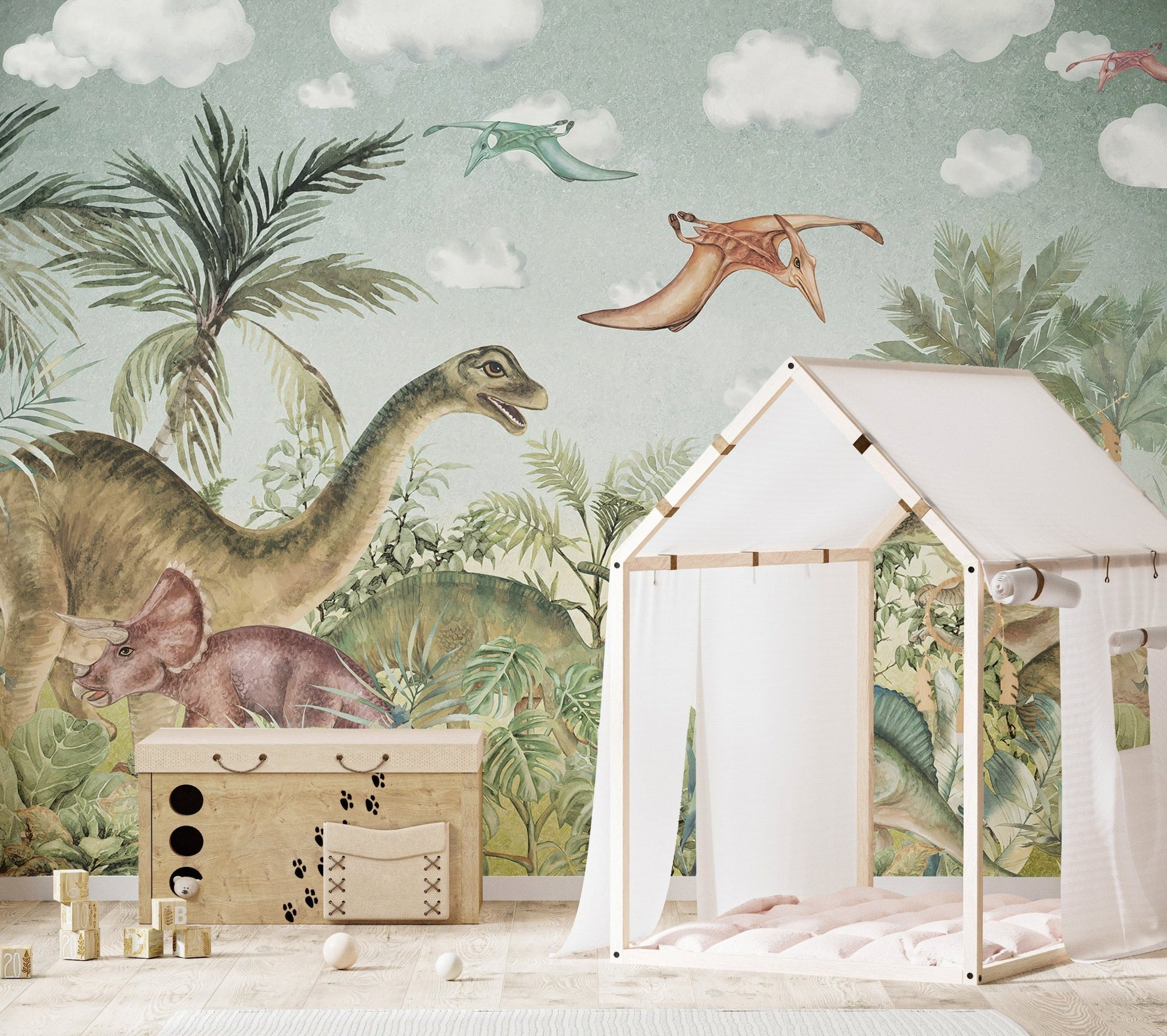 Dinosaur era wall mural behind a white play tent and wooden toy chest.