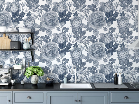 Blue tinted floral wallpaper as a kitchen backsplash behind a white sink.