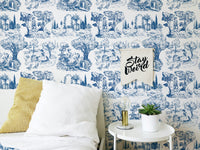 French style wallpaper in a bedroom with white pillows and a yellow cushion.