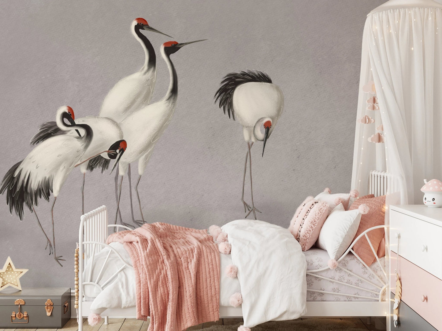 White crane bird wall mural behind a child’s bed with pink and white linens.