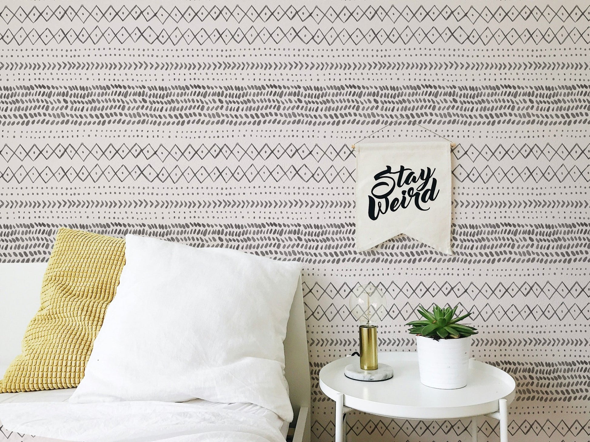 Bedroom corner with white pillows and boho style watercolor wall mural.