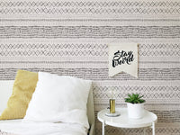Bedroom corner with white pillows and boho style watercolor wall mural.