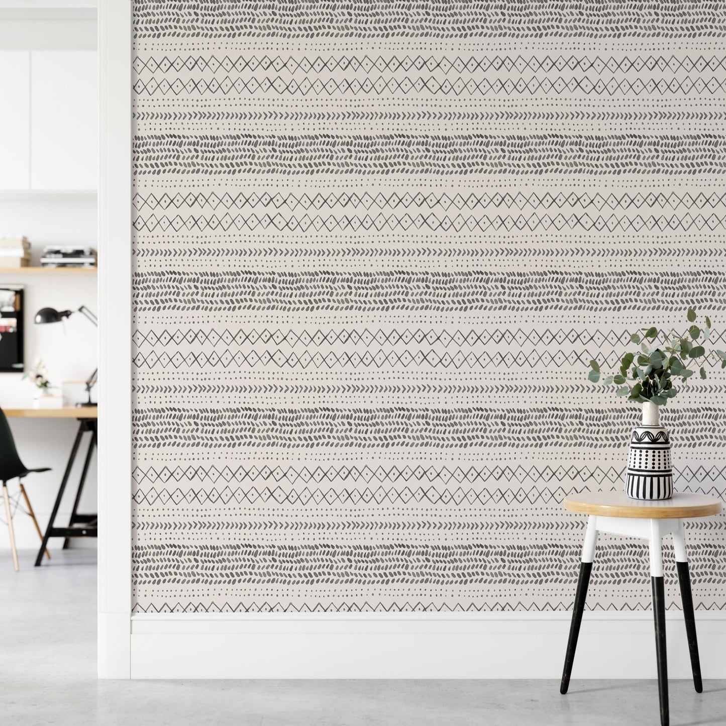 Minimalist hallway with a small stool and ethnic watercolor wall mural.