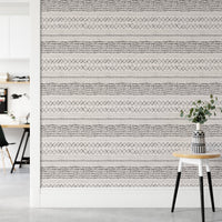 Minimalist hallway with a small stool and ethnic watercolor wall mural.