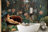 Freestanding white bathtub set against a botanical forest art wall mural.