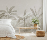 Neutral tropical wall mural with banana leaves and delicate landscape elements.