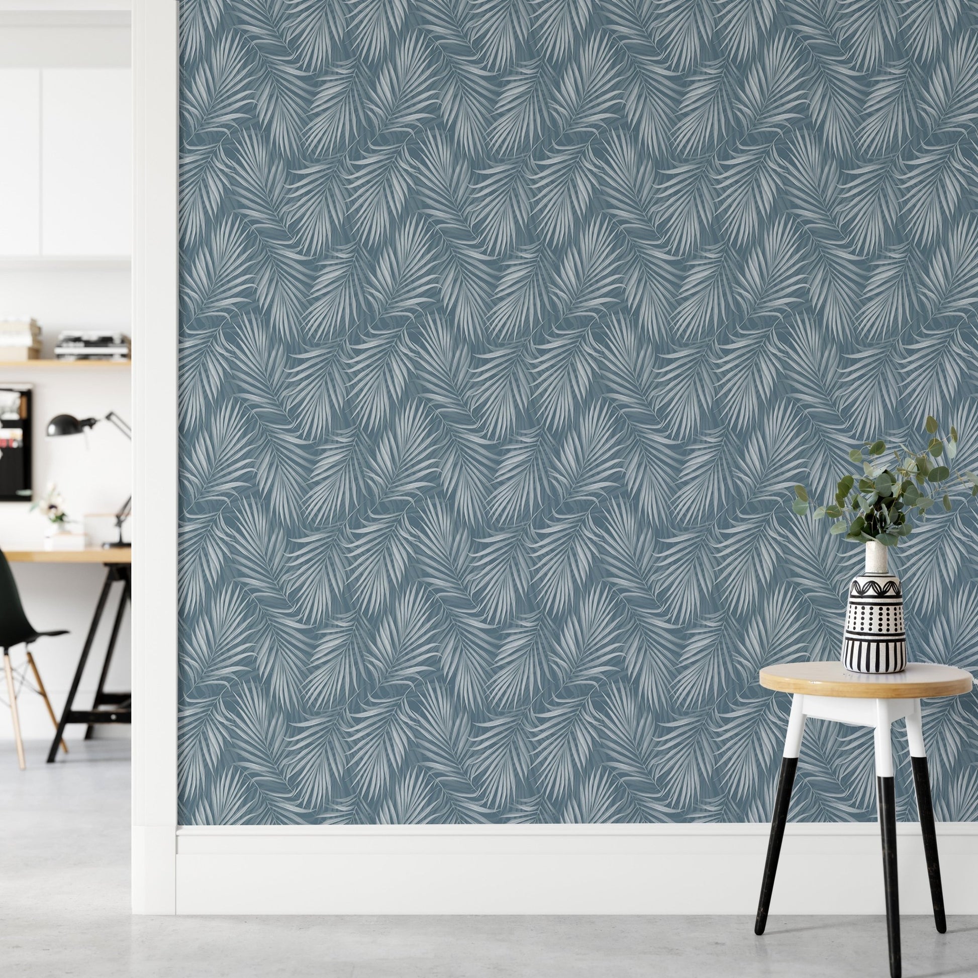 Minimalist hallway with a blue botanical wallpaper and a small white stool.
