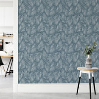 Minimalist hallway with a blue botanical wallpaper and a small white stool.