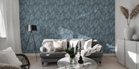 Living area with a grey sofa and a blue tropical leaf wallpaper.