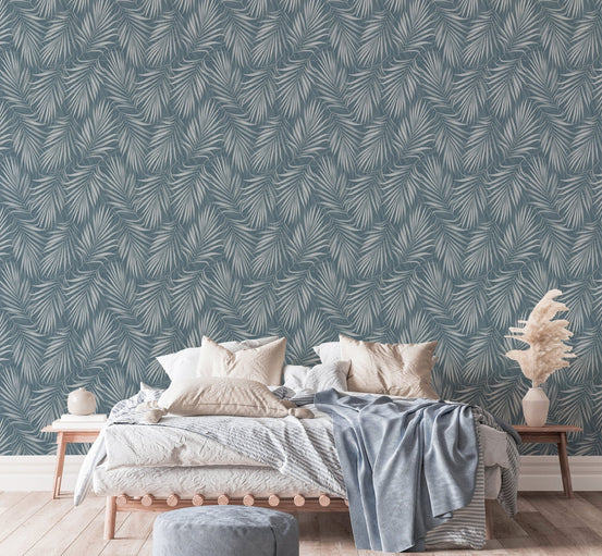 Tropical Exotic Palm Leaves Vintage Illustration Wallpaper behind a bed with grey pillows.