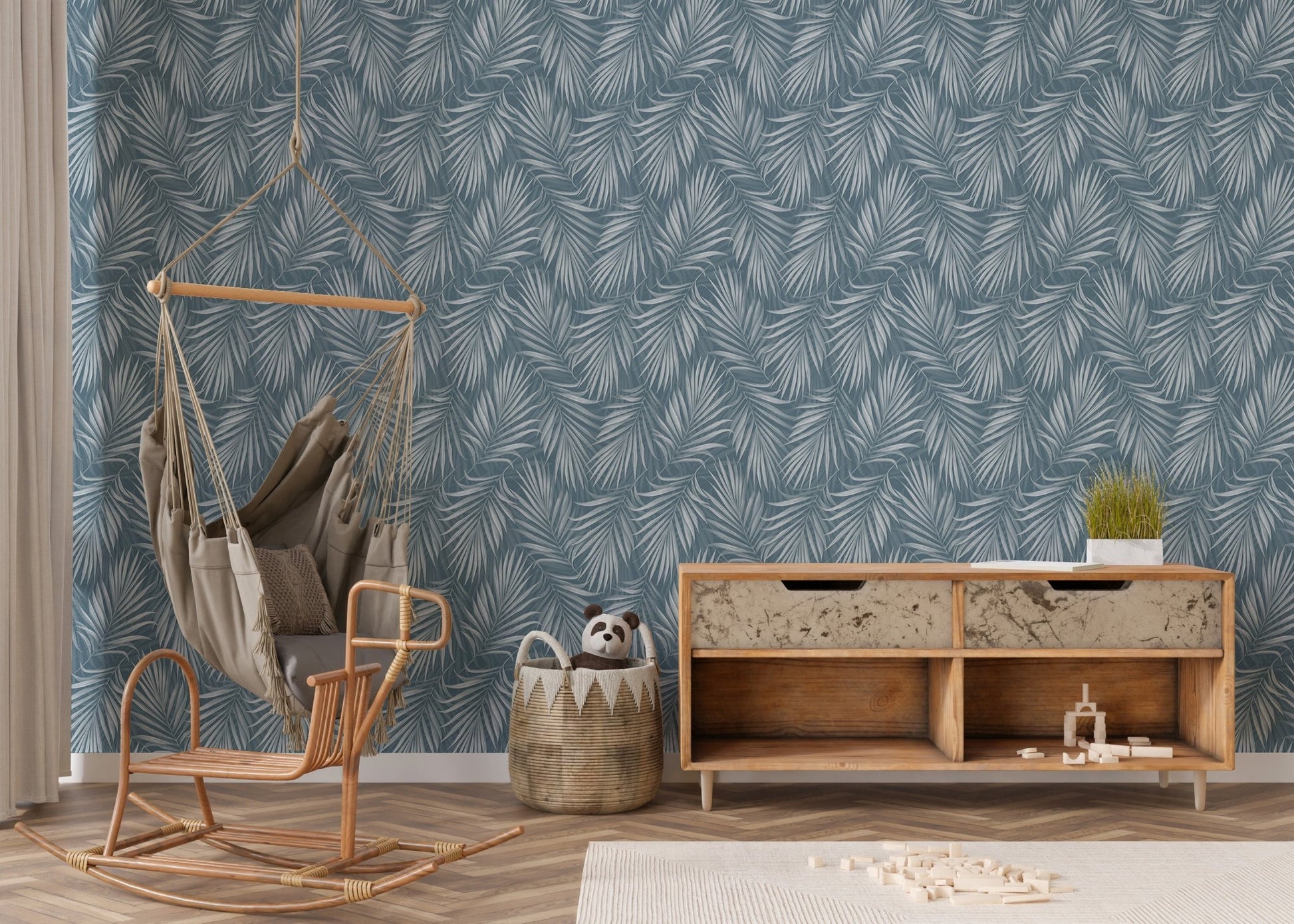 Nursery area with a rocking chair and the tropical exotic palm leaves wallpaper.