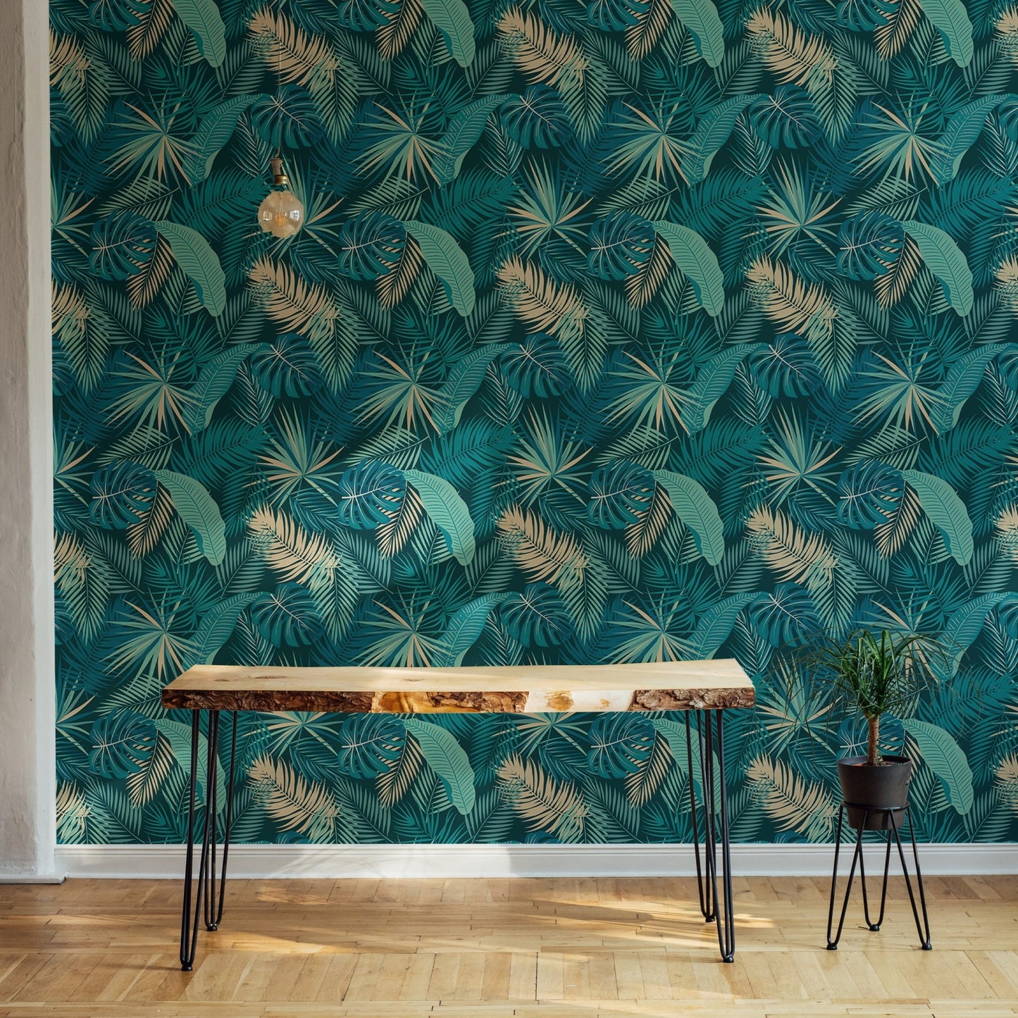 Teal palm leaf wallpaper in room with  wooden side table.