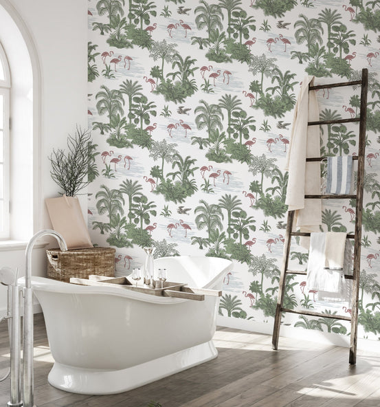Green palm tree and pink flamingo wallpaper in a bathroom with a white bathtub.