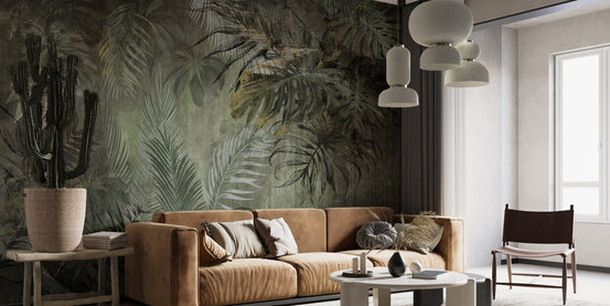 Green tropical wall mural behind a brown leather couch in a modern room.