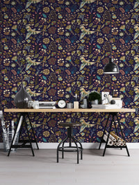 Dark blue flowers wallpaper with orange and yellow flora in a home office setup.