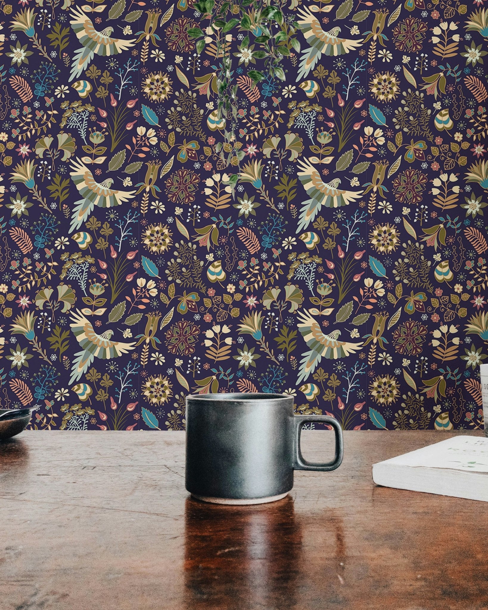 Dark flower wallpaper design placed behind a wooden desk with a black coffee mug.