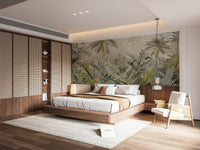 Muted green tropical palm leaf wall mural behind large bed with wooden headboard.