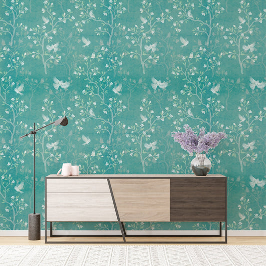 Chinoiserie wallpaper featuring bird and tree motifs behind a wooden sideboard.