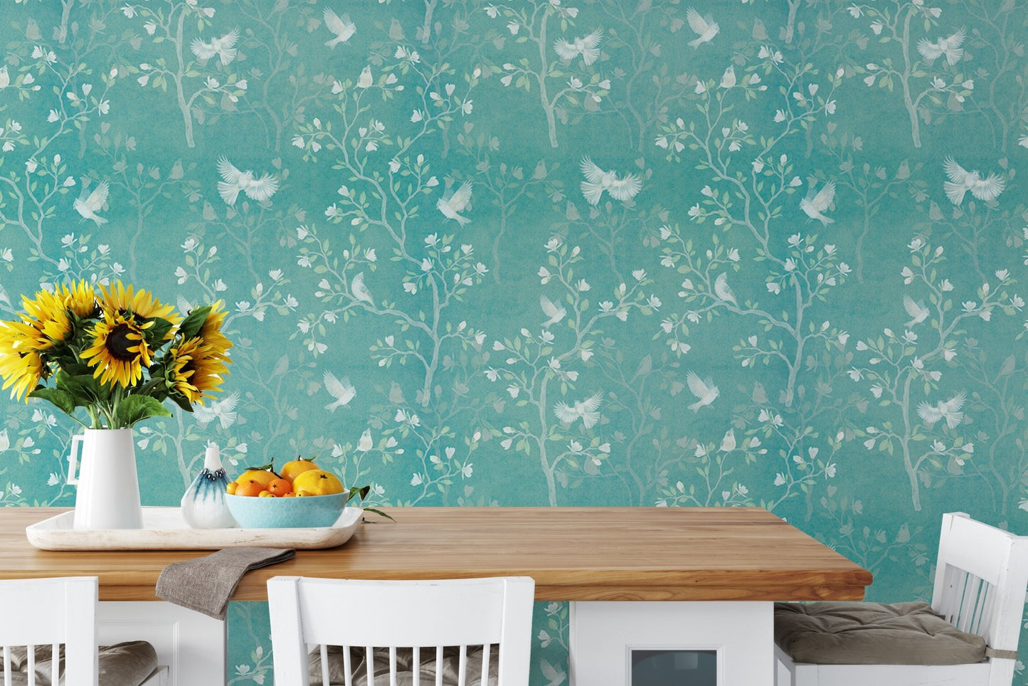 Floral Chinoiserie wallpaper as a backdrop for a wooden dining table setup.
