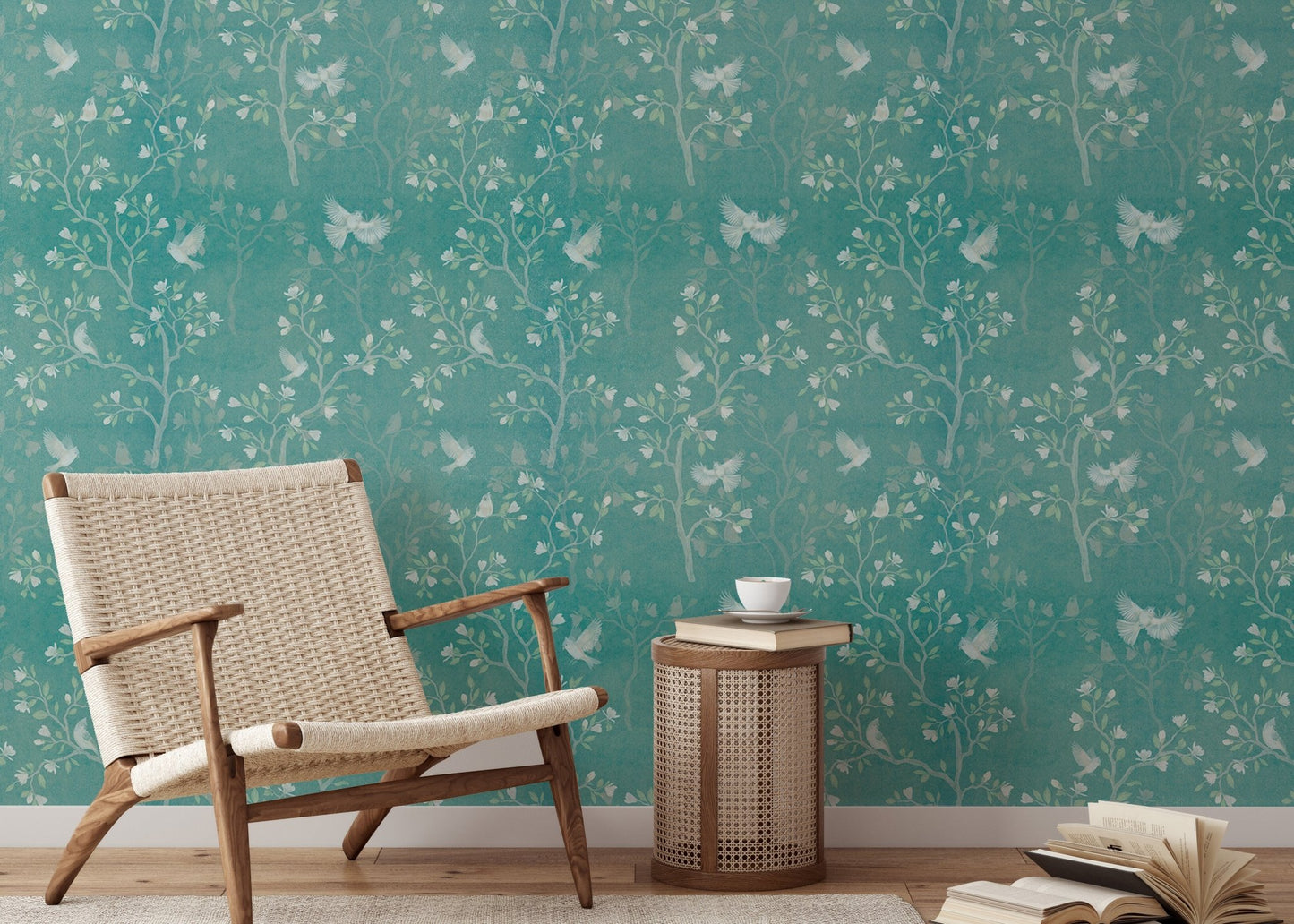 Turquoise wallpaper with botanical prints in a sunlit reading area with a side table.
