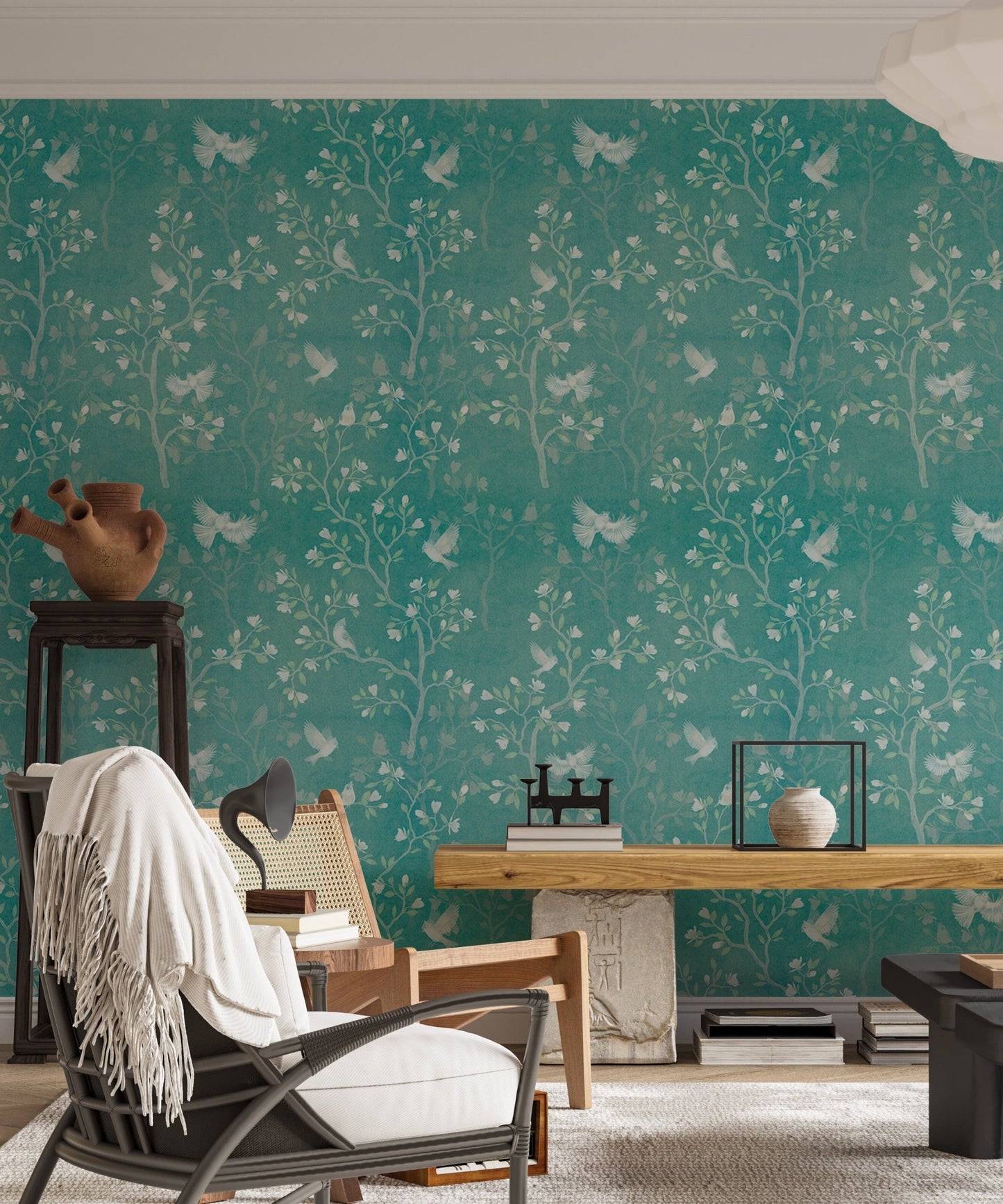 Chinoiserie wallpaper with birds and branches behind a dark chair in living area.
