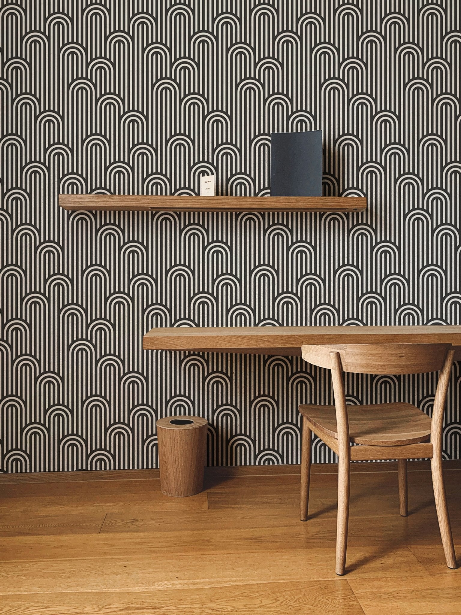 Geometric twisted lines wallpaper behind a study table and wooden chair