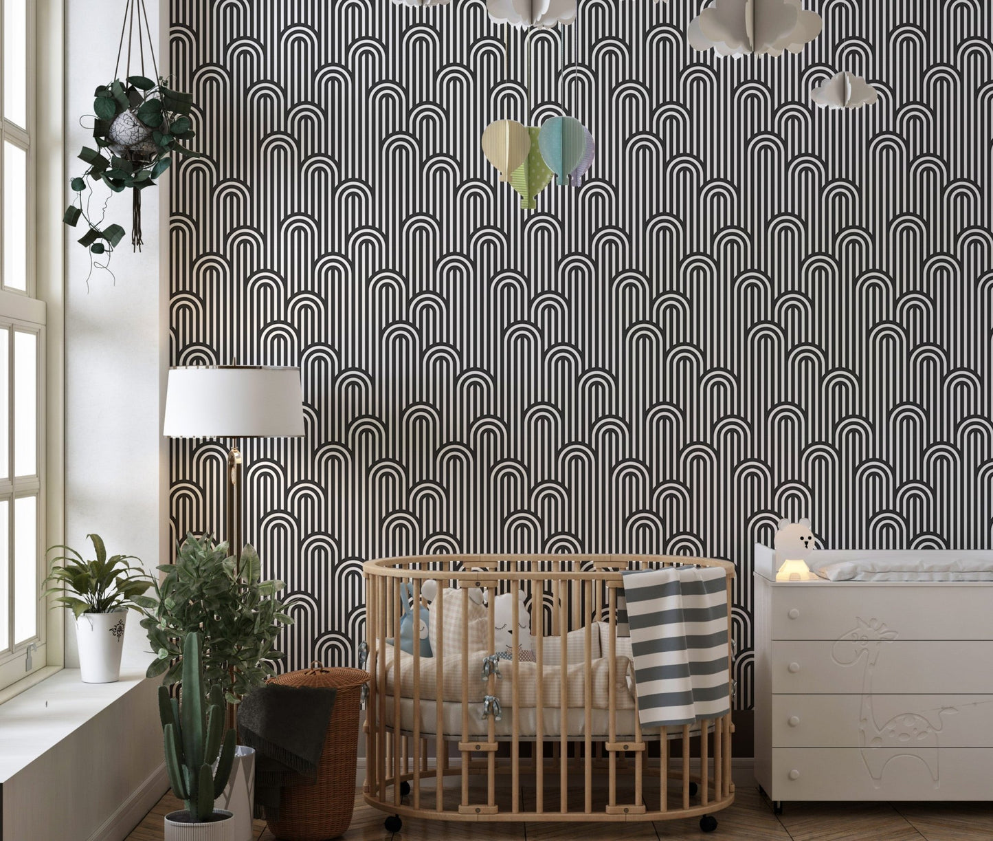 Black and white stripy wallpaper in a modern nursery with a wooden crib