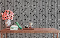 Black and white geometric wallpaper behind a console with pink flowers