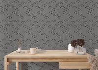 Minimalist black and white striped wallpaper behind a home office desk