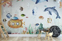Blue marine themed wall mural with tropical fish in a minimalist playroom.