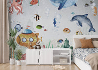 Blue water wall mural with aquatic animals in a room with a white storage cabinet.