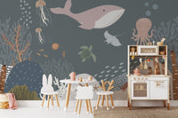 Hand-painted sea life wall mural behind a wooden play kitchen and table.