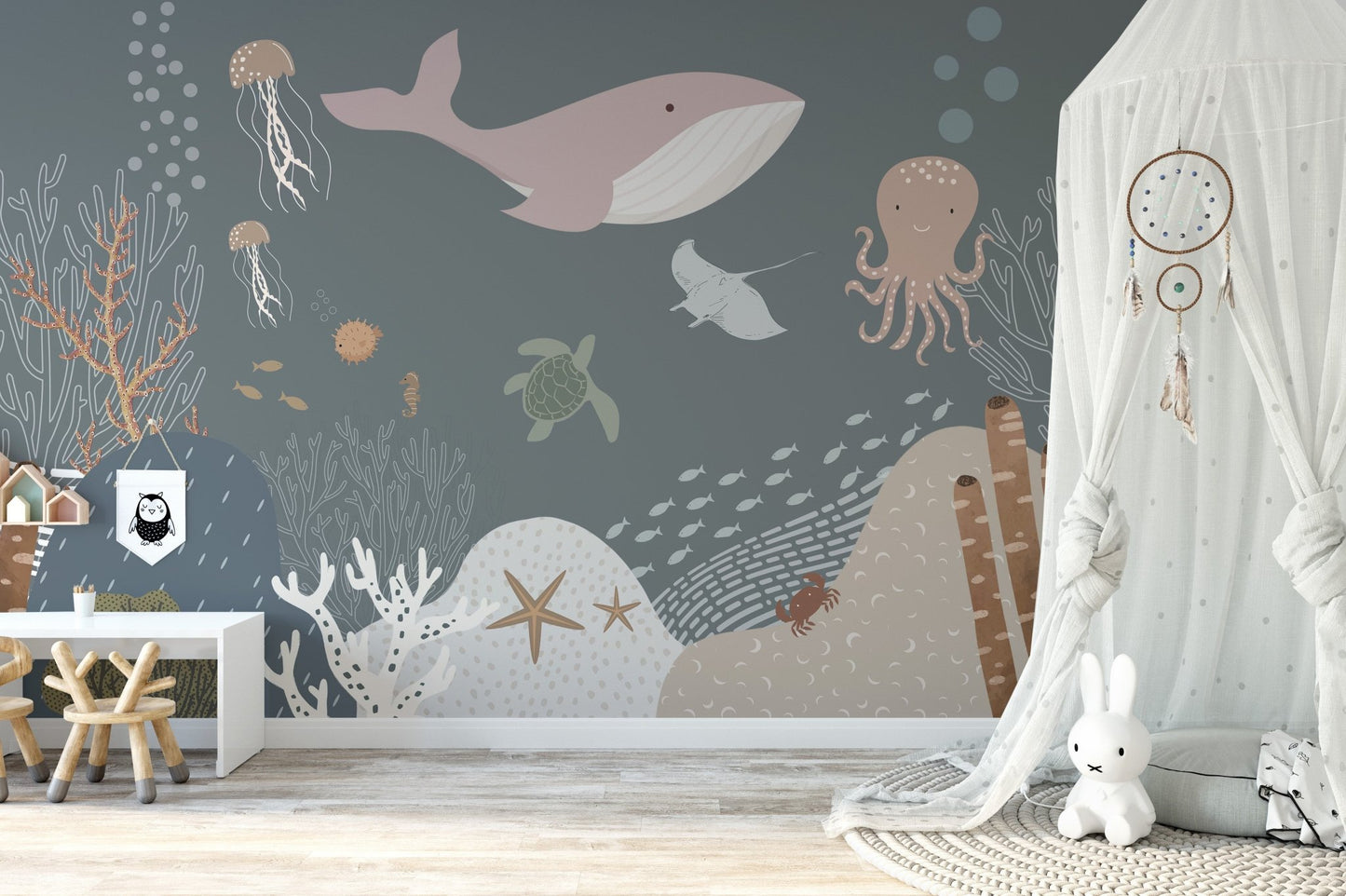Grey and pink underwater animal wall mural in a bright sunlit nursery room.