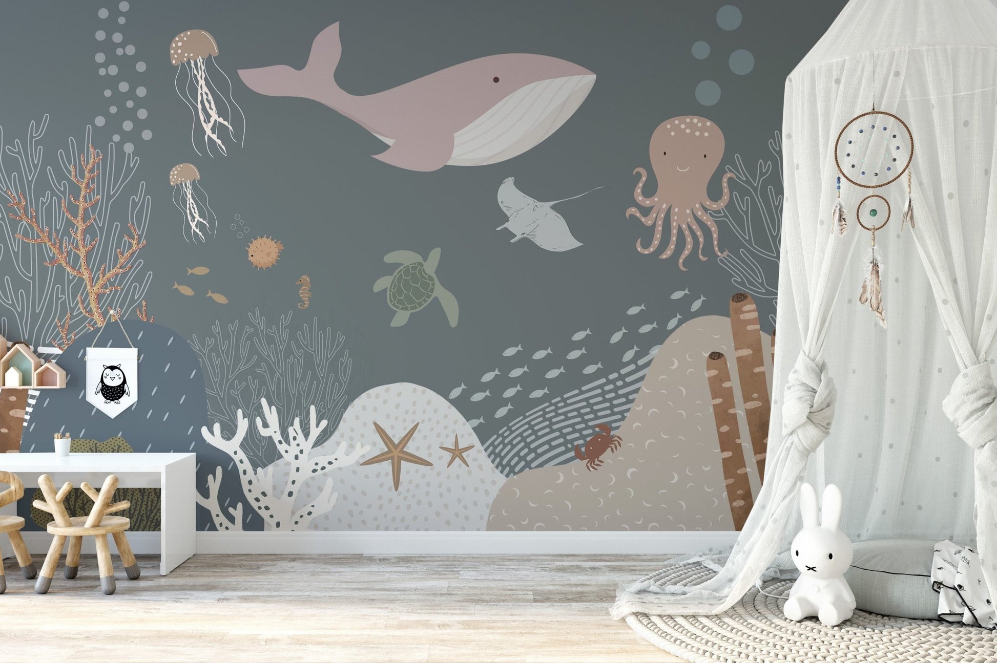 Grey and pink underwater animal wall mural in a bright sunlit nursery room.