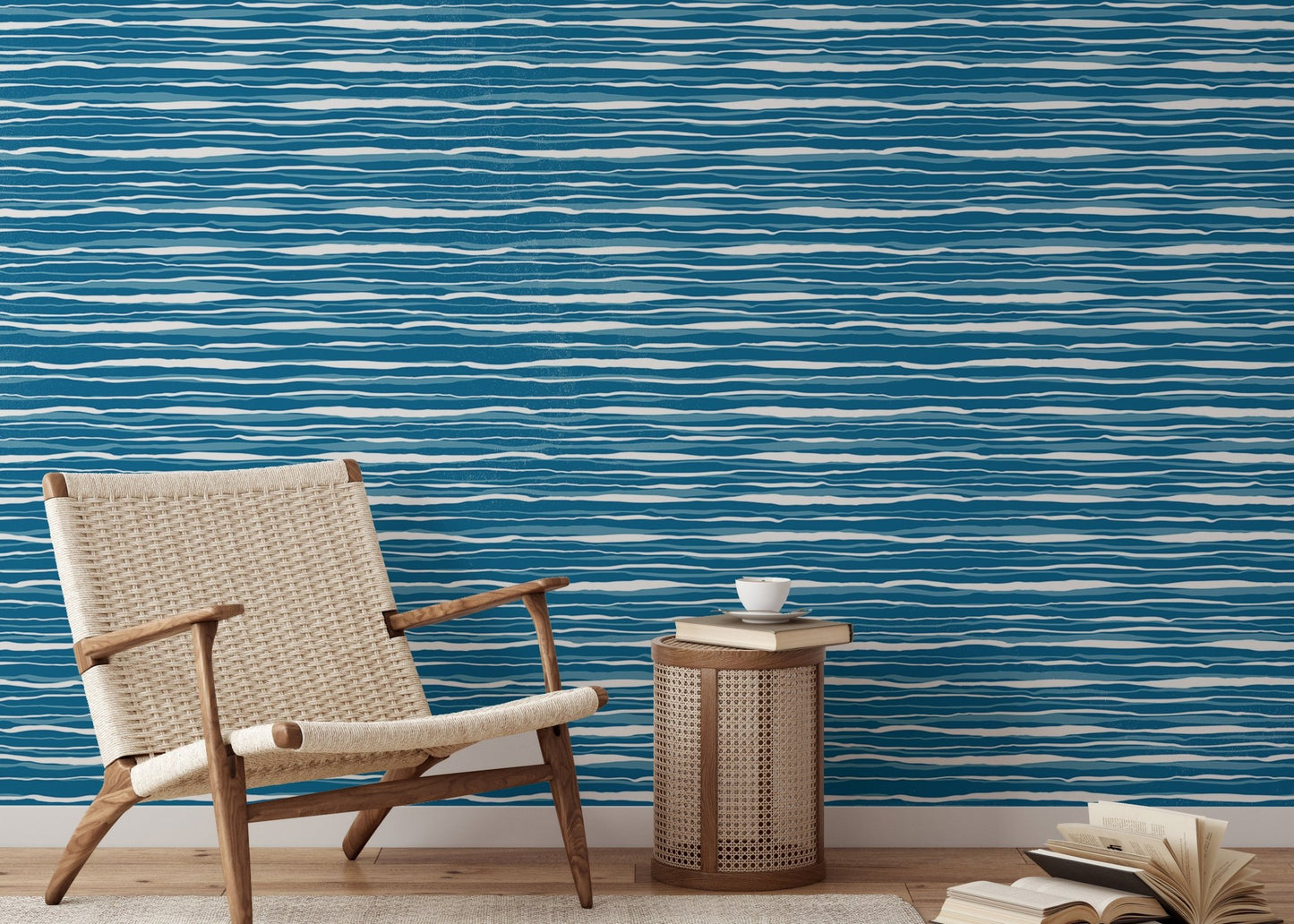 Modern reading area with blue ocean waves wallpaper and a woven chair.