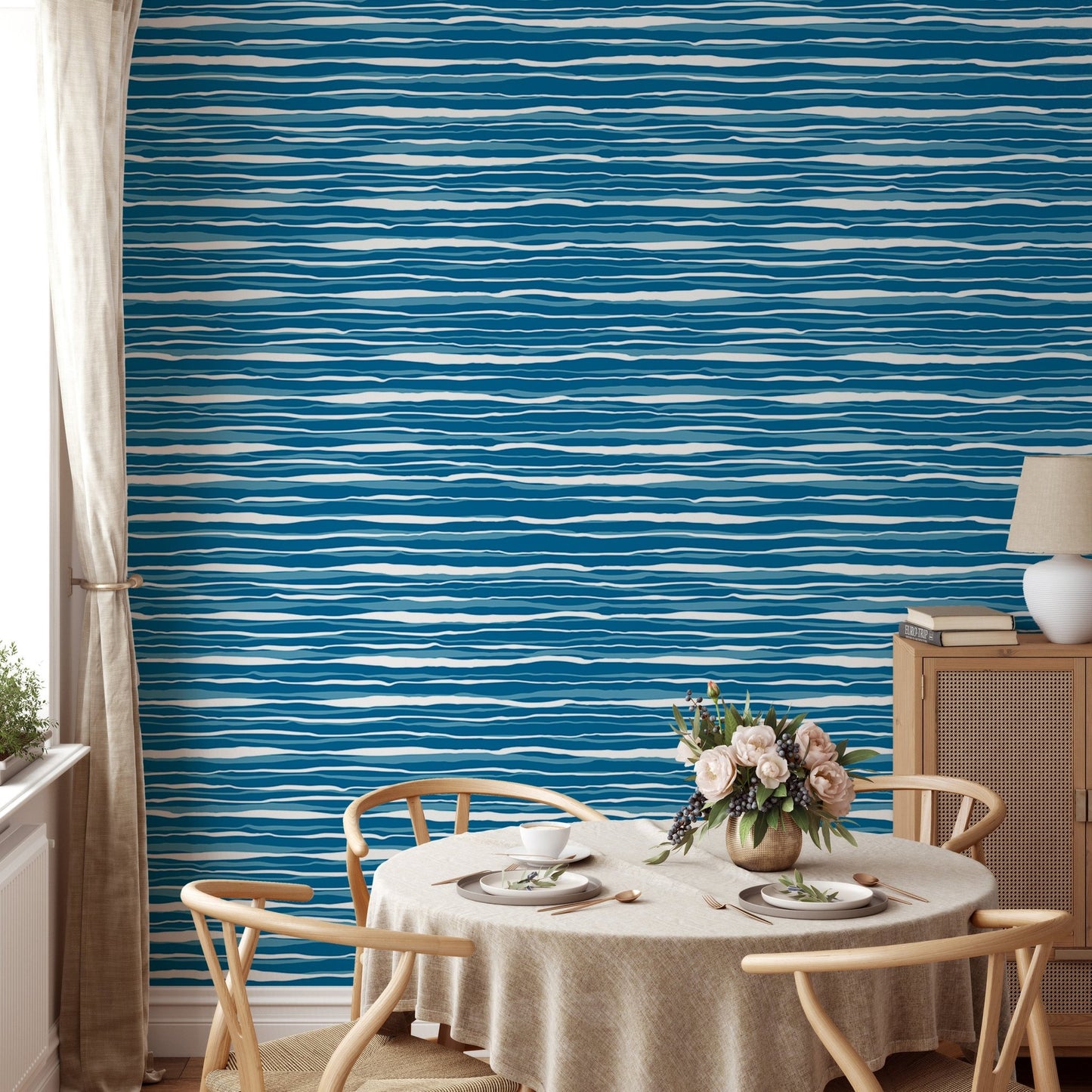 Circular dining table set against a blue water stripes tile wallpaper.
