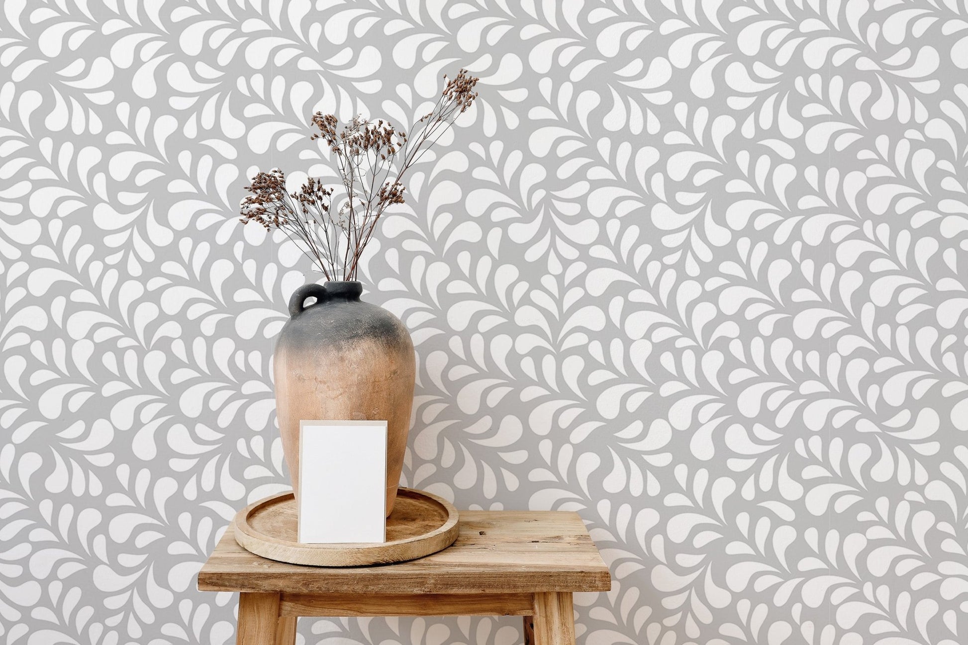Seamless white drops wallpaper behind a vase with dried branches.