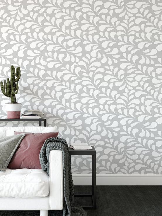 Abstract drop style wallpaper in a living room behind a white sofa.