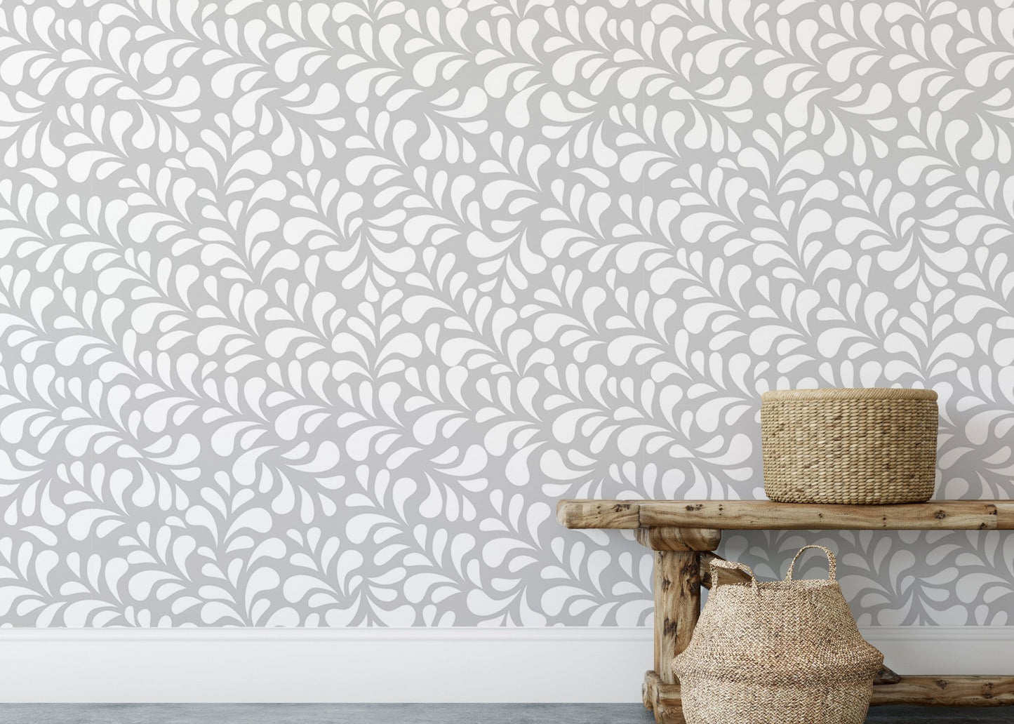 Neutral damask wallpaper behind a wooden bench and woven baskets.