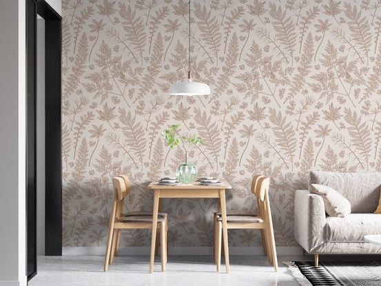 Cream leaf wallpaper in an open plan dining space with a grey sofa and wooden table.