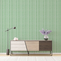 Console table against watercolor green stripes vintage wallpaper.